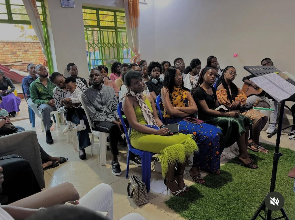 Groupe de prière en cercle tenant la main dans une église avec lumière chaude filtrant par les vitraux